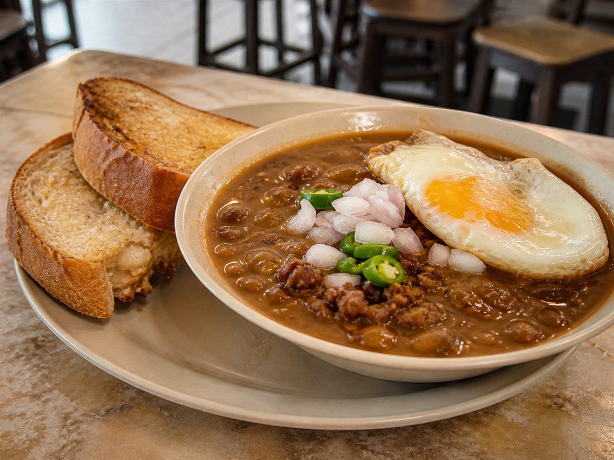 Johor-style kacang pool with bean stew, minced beef, fried egg and toast