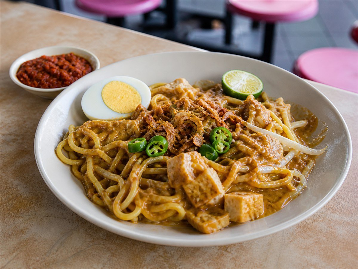 Johor mee rebus with thick gravy, egg, tofu, bean sprouts, chilli and lime